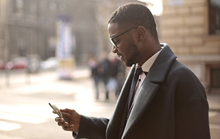 Automate Communication by Tracking Customer Behaviour | Everlytic | Blog feature image | Email Automation | African businessman on mobile