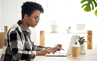 Everlytic | Blog | How to Reduce Your Email Bounce Rate & Boost Deliverability | African Woman Working on Laptop | Feature Image