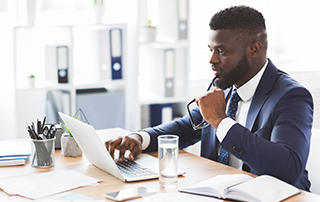 Key Email Metrics & the Business Goals They Help You Achieve | Everlytic | Email marketing | Marketing automation | Businessman working on a laptop | Blog feature image