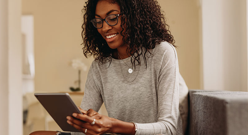 Everlytic | Lead Nurturing | Blog | 8 Things to Check Before Sending Your Email Marketing Campaign | African Lady Wearing Glasses | Using Mobile Device