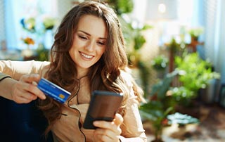 Why Your Business Needs Transactional Email & SMS | Everlytic | Transactional Messaging | Feature Image | Woman With Credit Card & Cell Phone