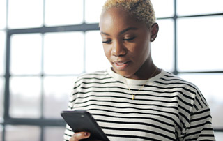 5 Data Compliance Traps to Avoid in SMS Marketing | Everlytic | Woman reading off a cell phone | Feature image